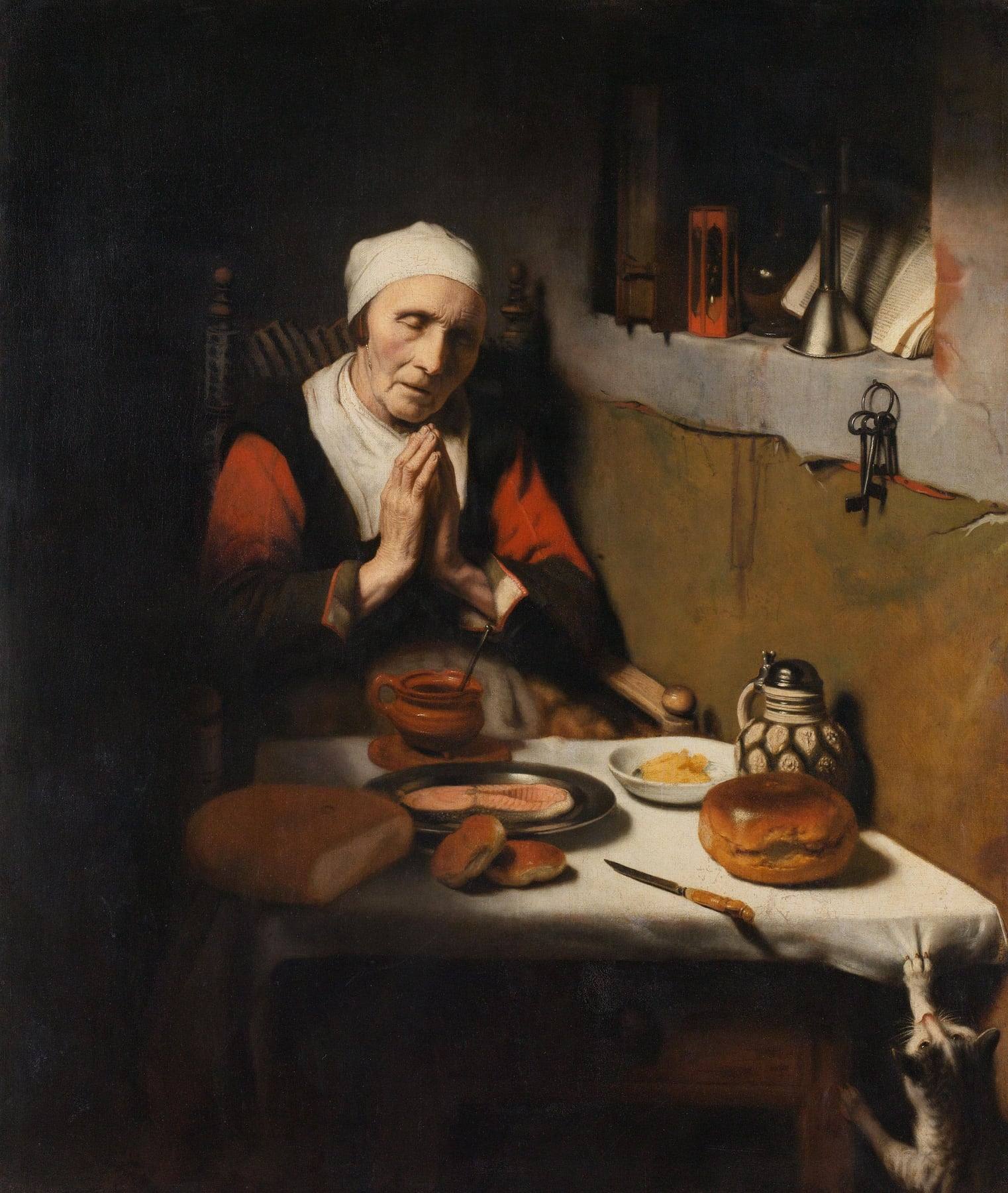 Nicolaes Maes’s painting of an elderly woman in a white cap seated at a table with eyes closed and hands folded in prayer before bread, fish and a jug, while a cat paws at the tablecloth and an open book stands on a shelf behind her.